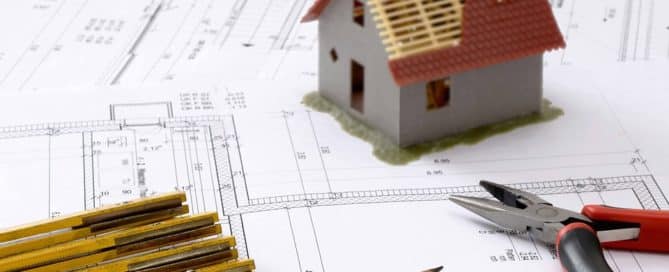 Small house, pliers, and pencils on floor plan