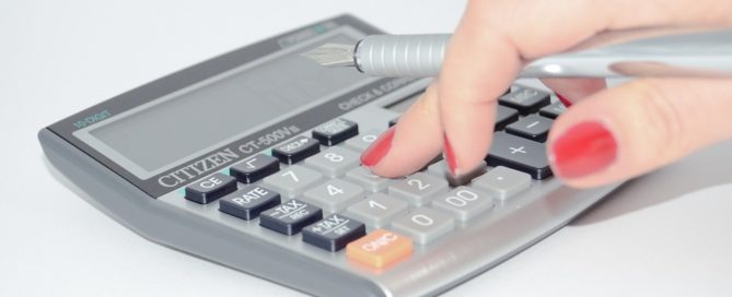 hand typing on calculator