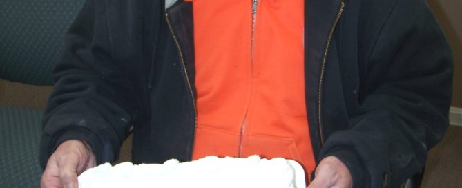 Man retiring, holding a congratulations cake