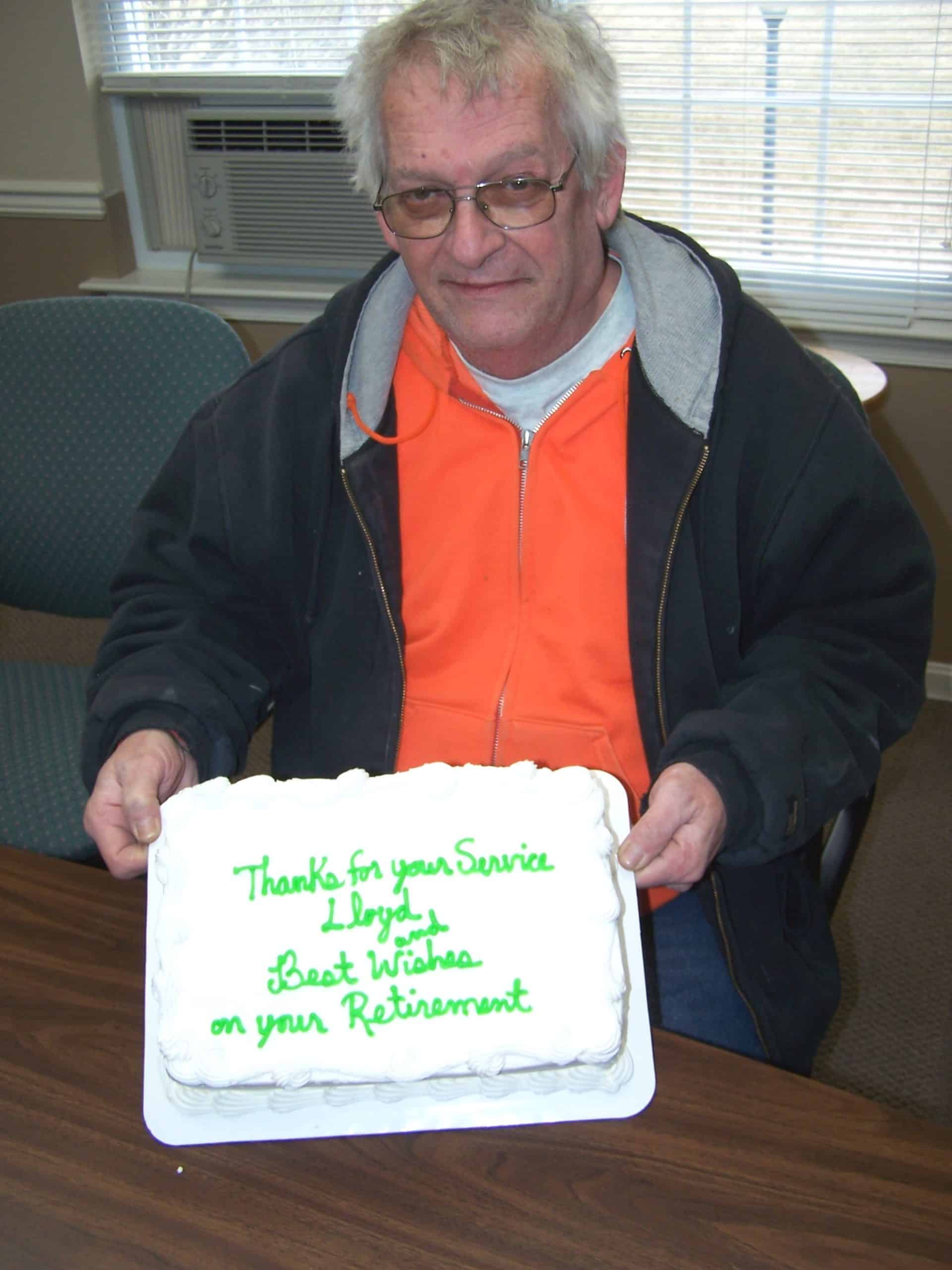 Man retiring, holding a congratulations cake