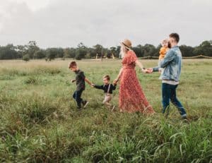 Couple and children walking through a grassy field