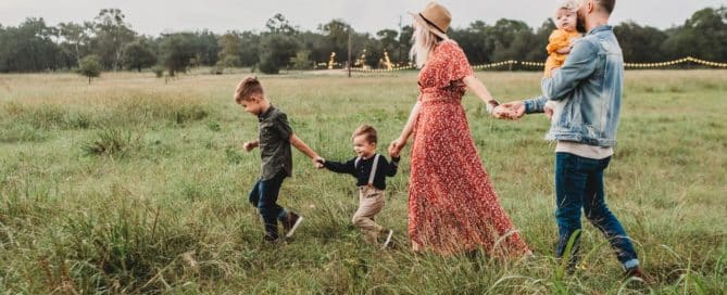 Couple and children walking through a grassy field
