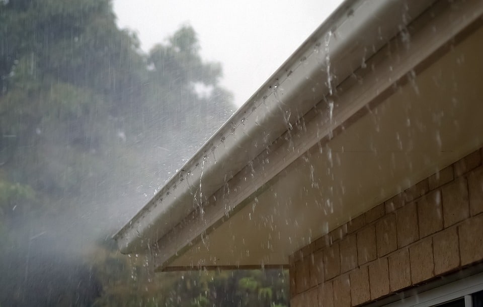 heavy rain pouring over a gutter