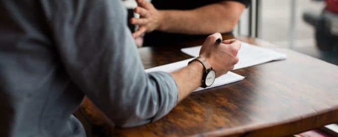 two people having a discussion over paperwork