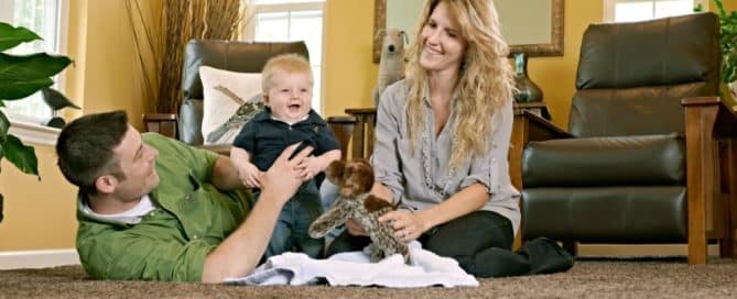 Couple playing with baby on the living room floor
