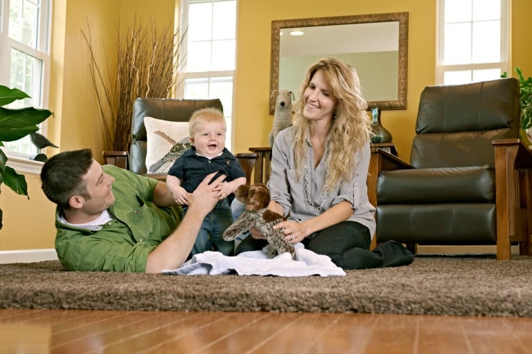 Couple playing with baby on the living room floor