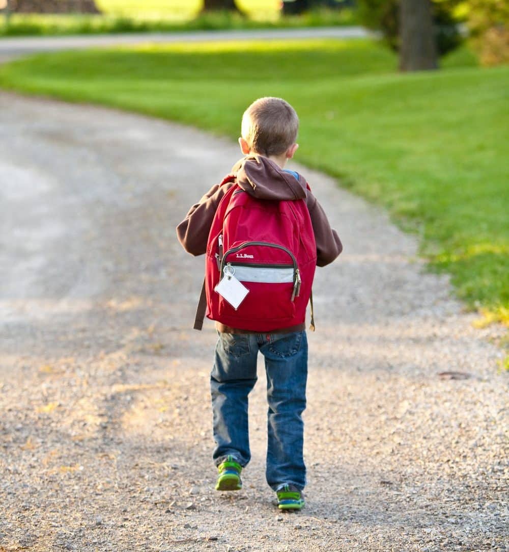 kid walking down driveway to go to school