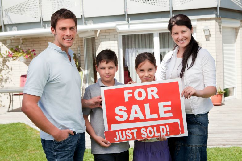 Family with for sale, just sold sign