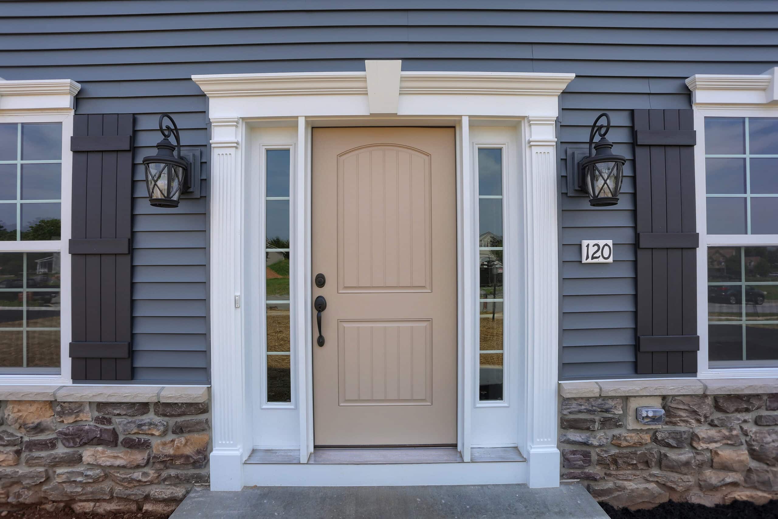 Exterior of a home with a tan colored entry doro