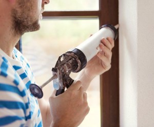 Man caulking a window