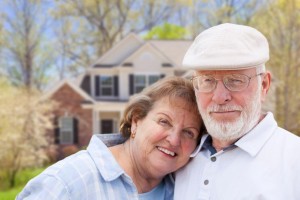 retired couple in front of their home